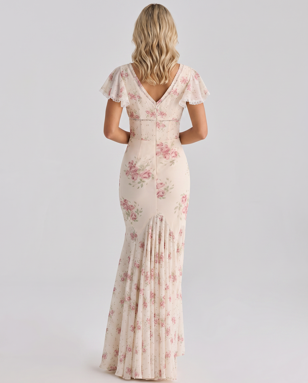  Female modelling a botanical print dress with a lightweight design on a plain background.