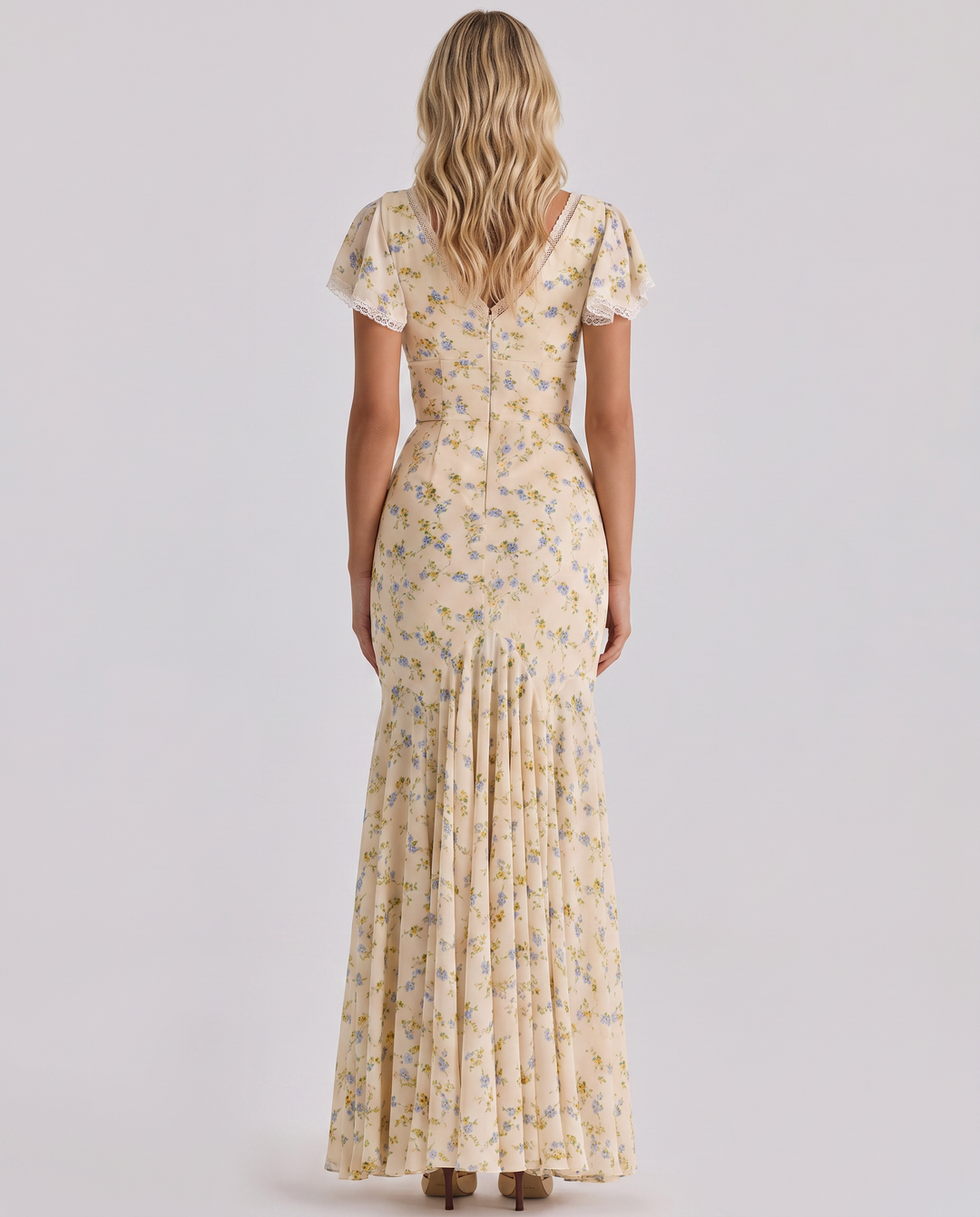 Female in a lightweight dress with botanical motifs and a flattering silhouette.