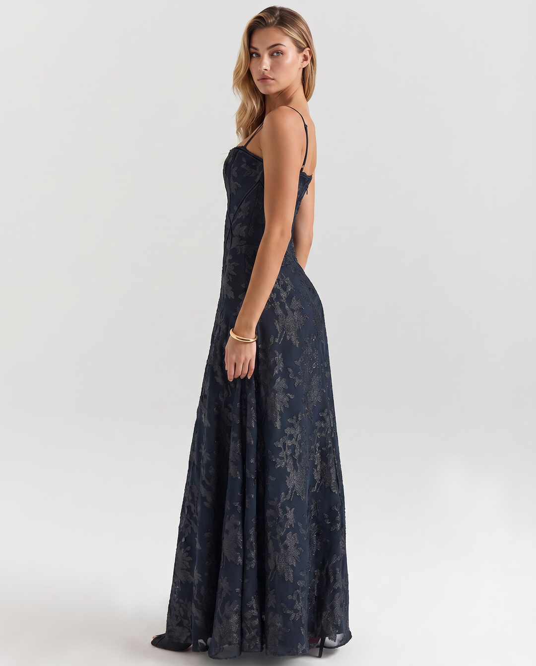 Woman in an occasion dress featuring a fitted bodice and flowing skirt.