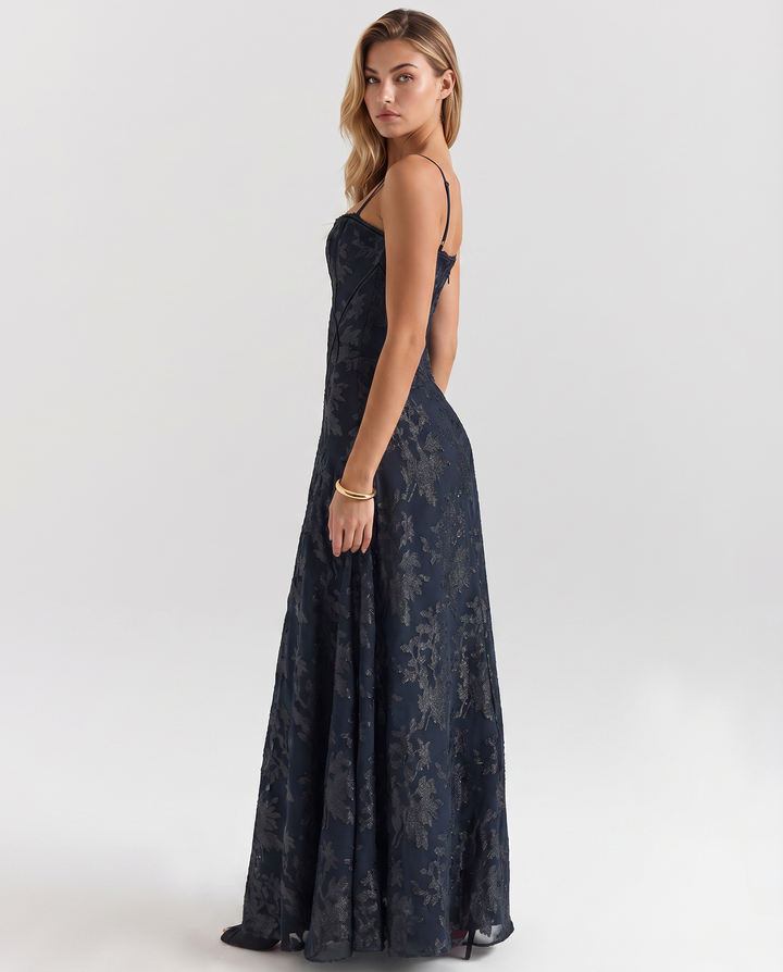 Woman in an occasion dress featuring a fitted bodice and flowing skirt.