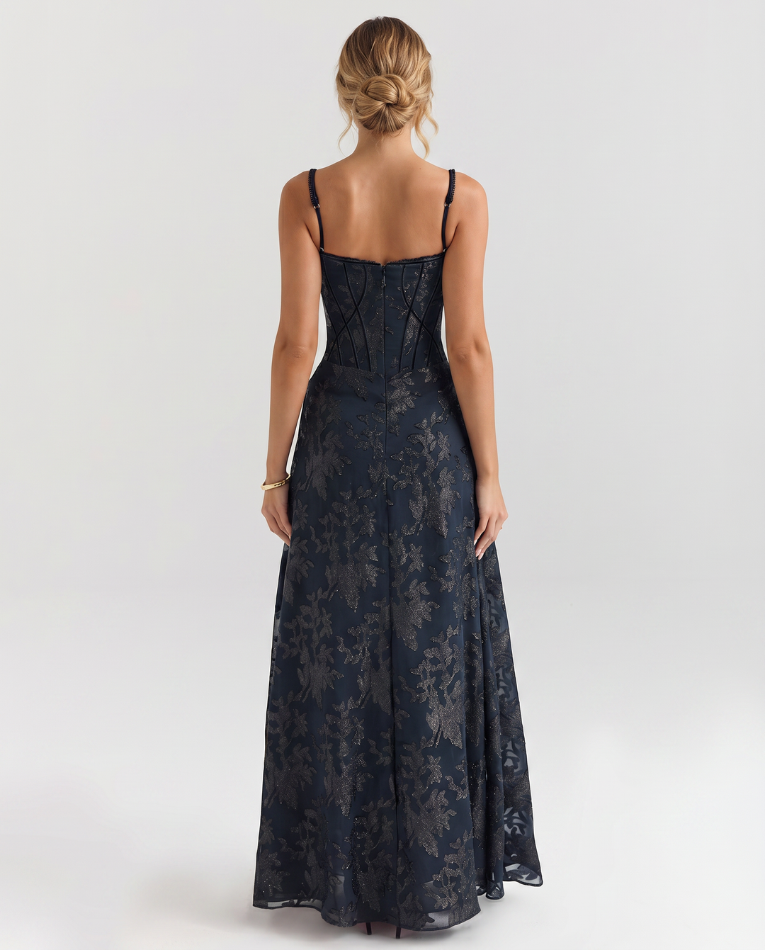 Female modelling a full-length dress with slender straps and a defined silhouette.