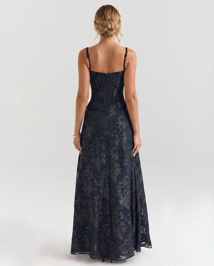 Female modelling a full-length dress with slender straps and a defined silhouette.
