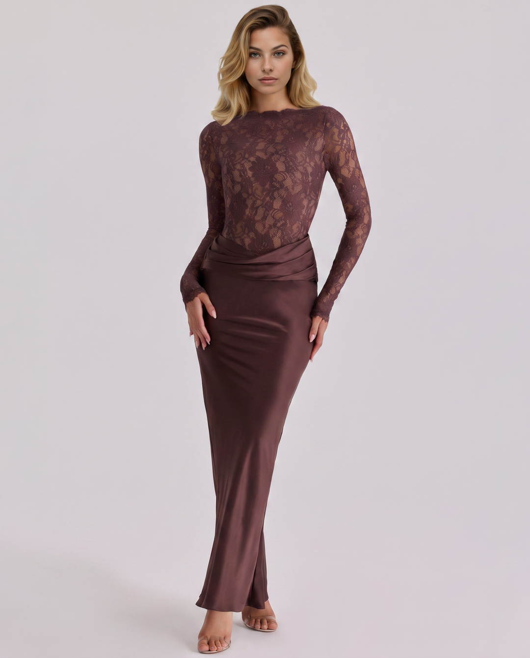 Female wearing a lace long sleeve maxi dress with a flowing satin-look skirt on a plain background.