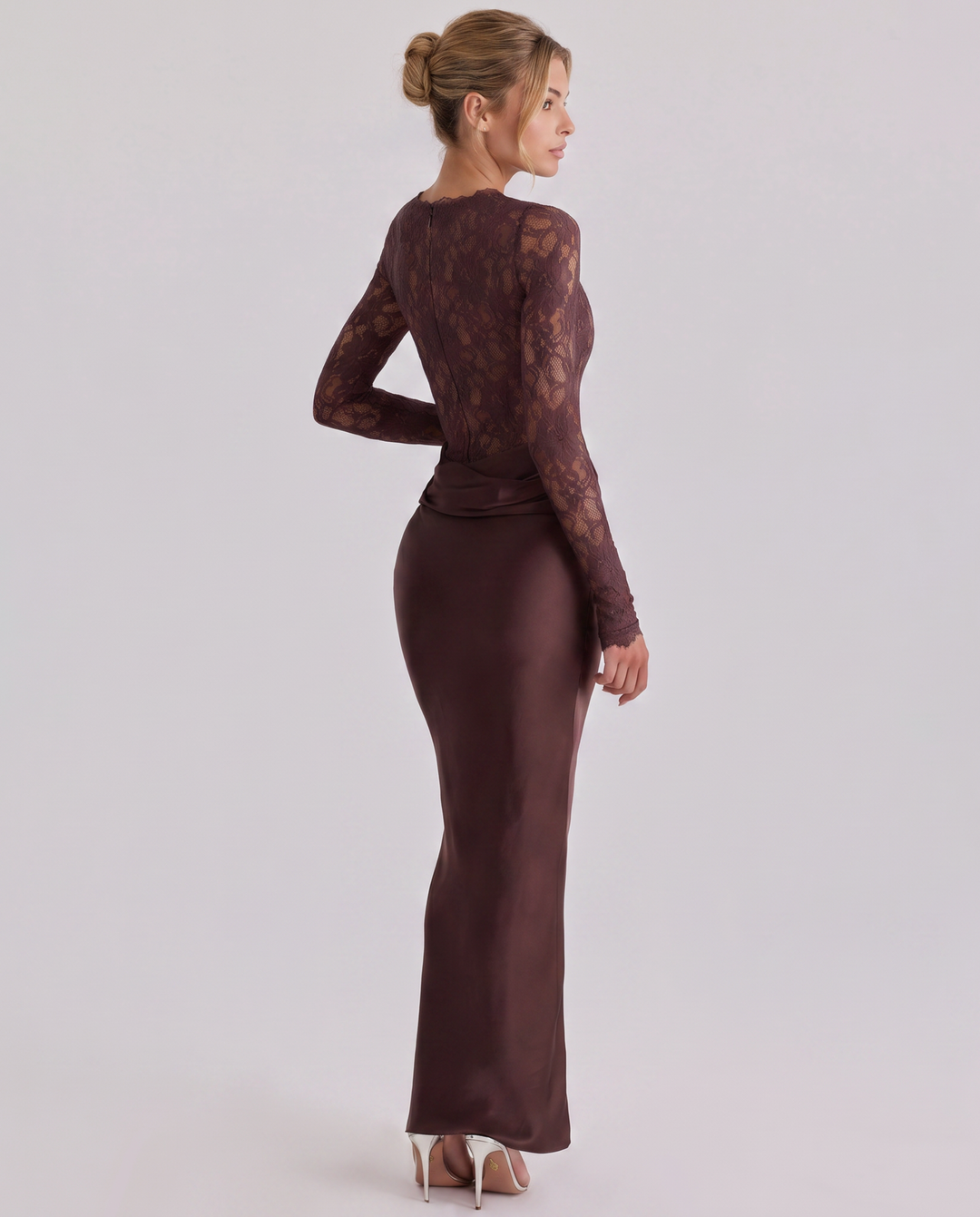 Model showcasing a long sleeve lace top dress with a fluid full-length skirt on a plain background.