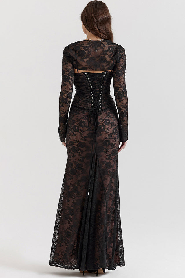 Woman modelling a lace maxi dress with a corset-style back and flowing hemline.