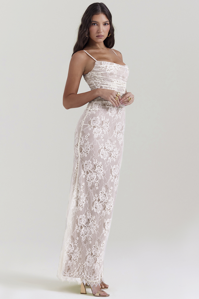 Female wearing a lace dress with a flowing silhouette and corset back detail.