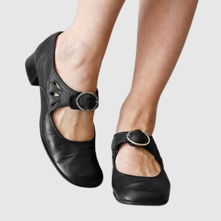 Woman wearing classic slip-on shoes against a plain background.