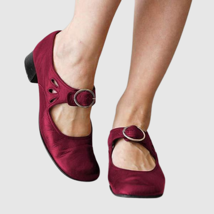 Female model wearing sleek everyday shoes on a plain background.