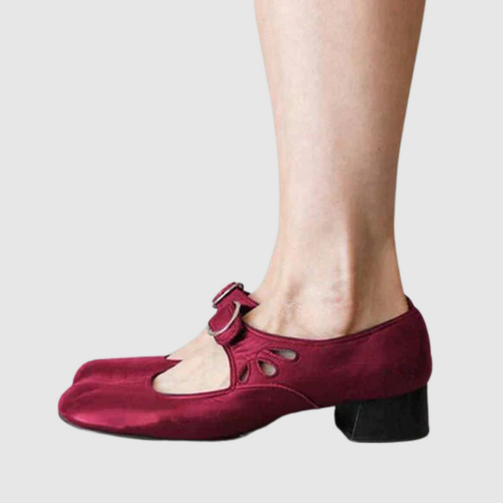 Female model wearing refined slip-on shoes on a plain background.