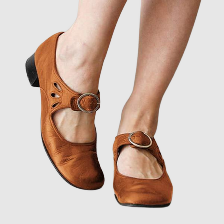 Woman showcasing slip-on shoes with a clean plain background.