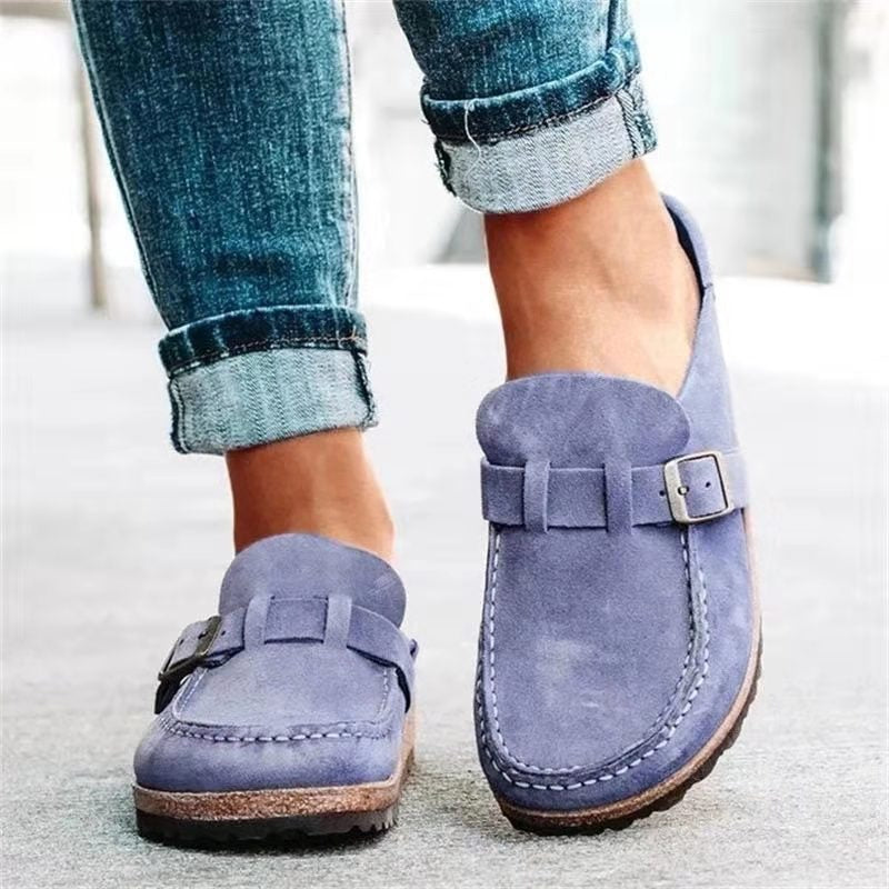 Female model showcasing casual slip-on shoes with textured outsole on a plain background.