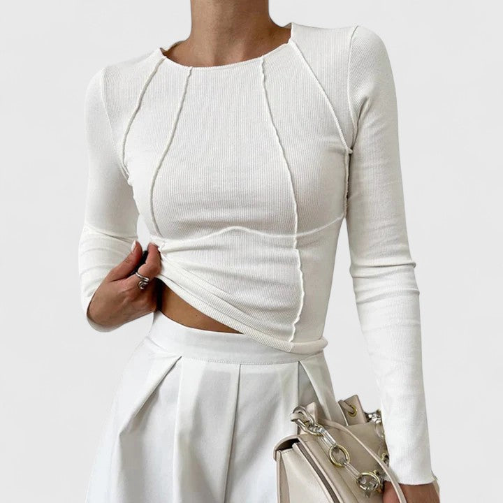 Woman wearing a tailored top against a plain background for a clean everyday outfit.