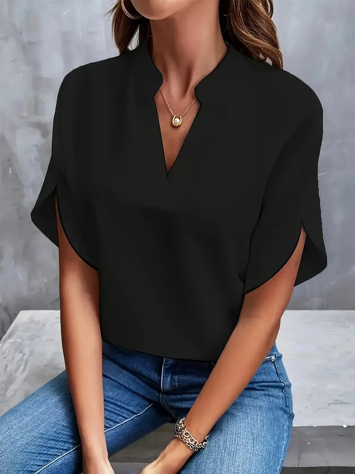  Female wearing a relaxed fit blouse on a plain background.