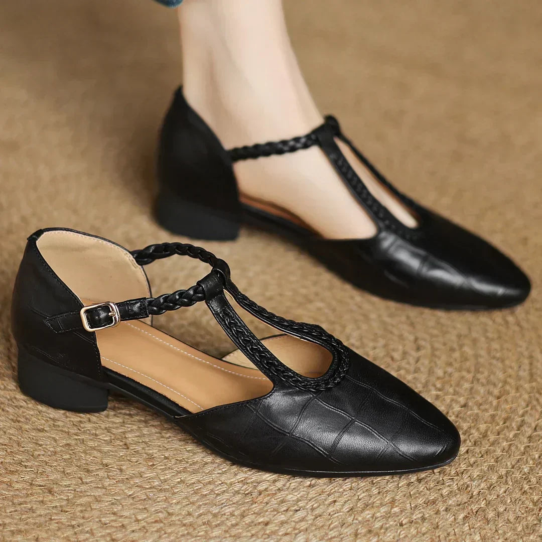 Classic T-strap Mary Jane flat shoe in black on a clean plain background.