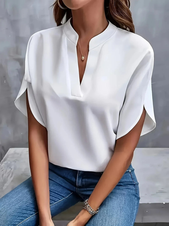  Female modelling a flowing blouse with a flattering V-neck design.