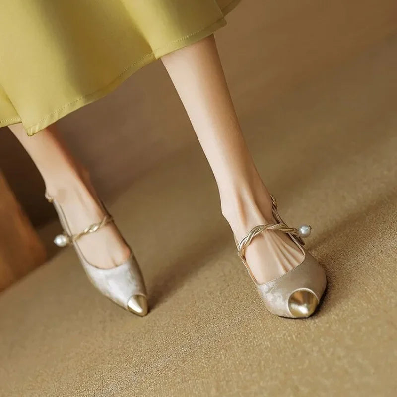 Pearl strap slingback shoe with low heel displayed on a plain background.