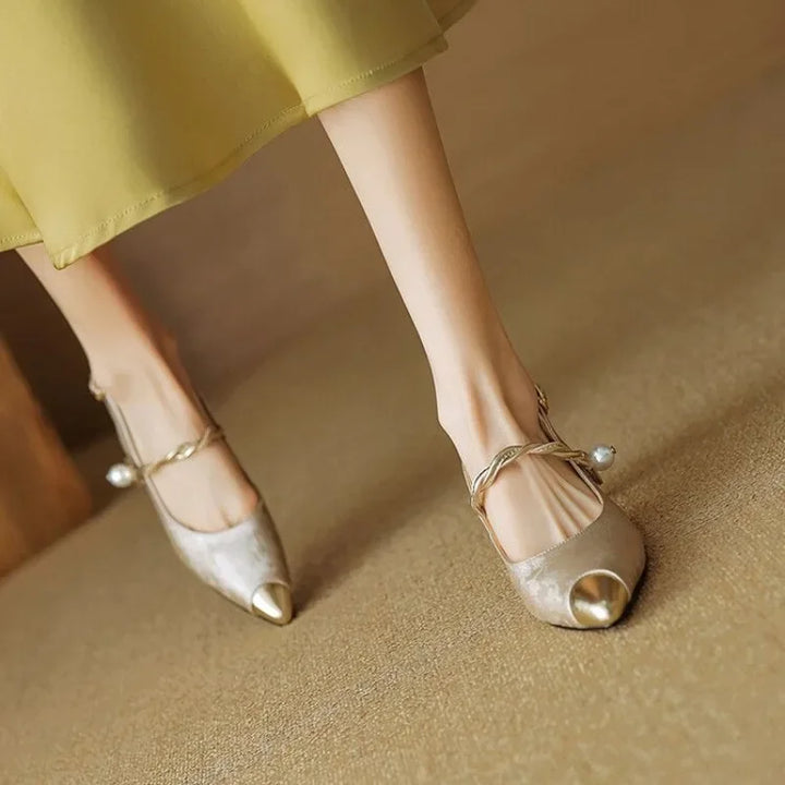 Pearl strap slingback shoe with low heel displayed on a plain background.