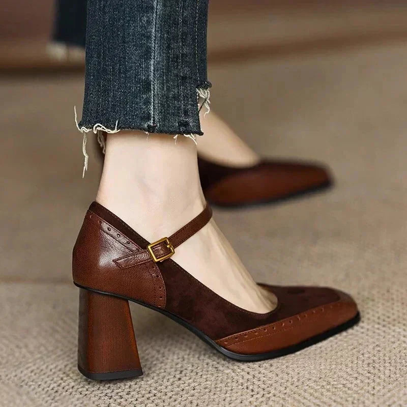 Woman wearing square toe block heel pumps with ankle straps on a plain background.
