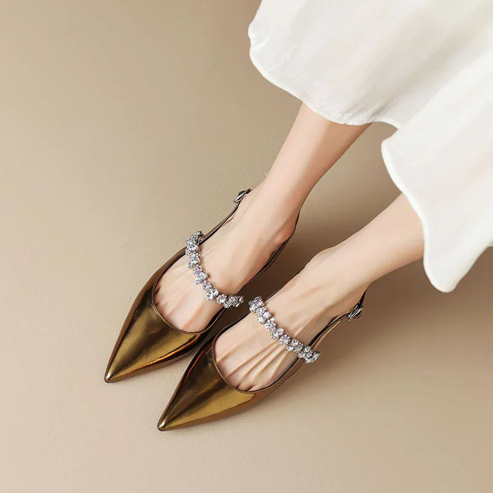 Female model wearing crystal embellished slingback shoes against a plain background.