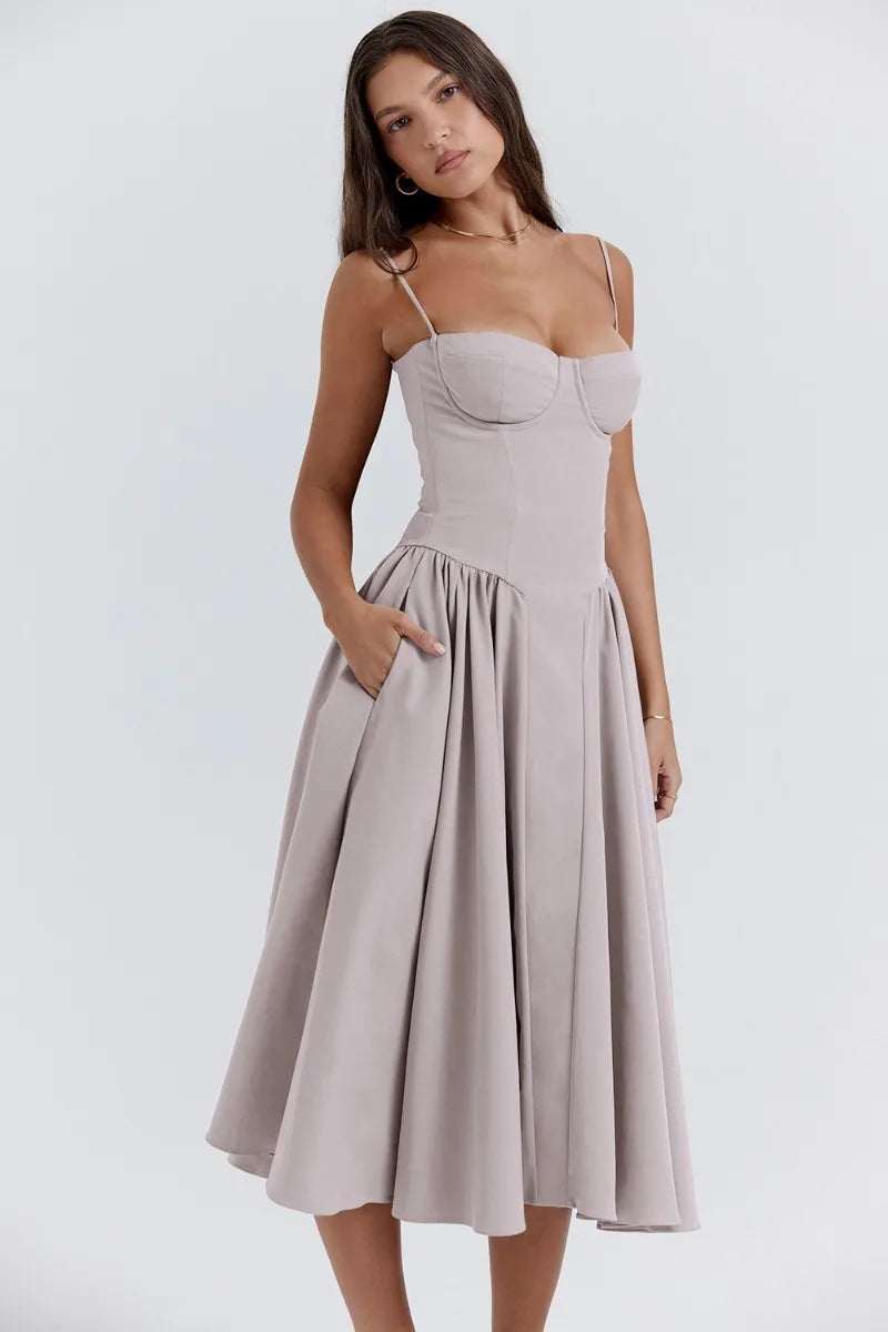 Model wearing a sleeveless midi dress with relaxed movement on a plain background.