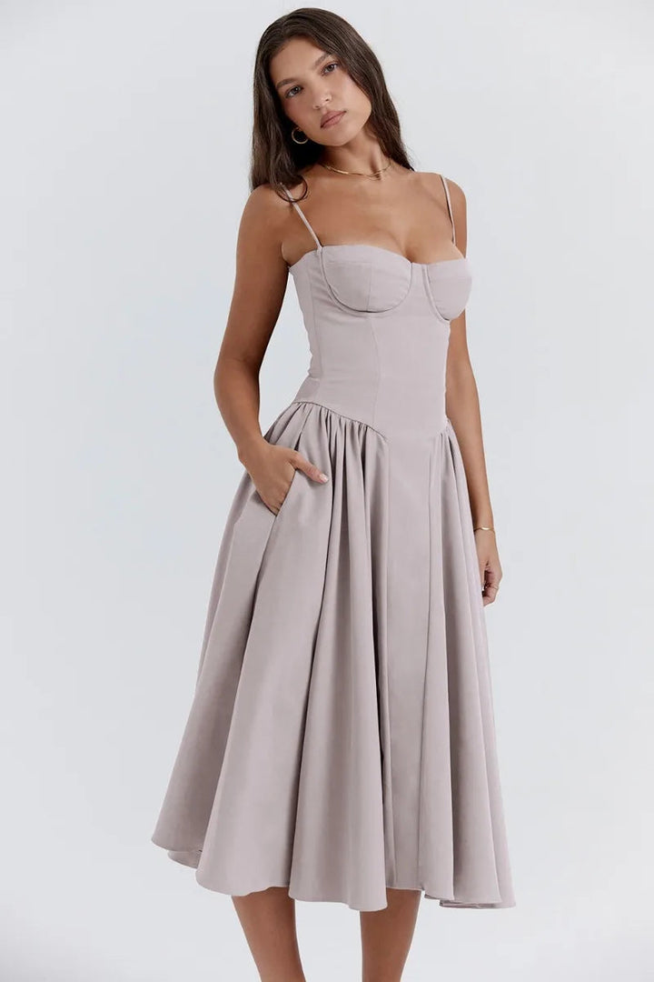 Model wearing a sleeveless midi dress with relaxed movement on a plain background.