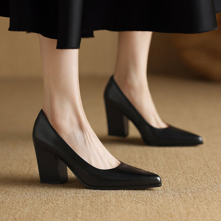 Woman modelling tan block heel shoes with a clean silhouette on a plain background.