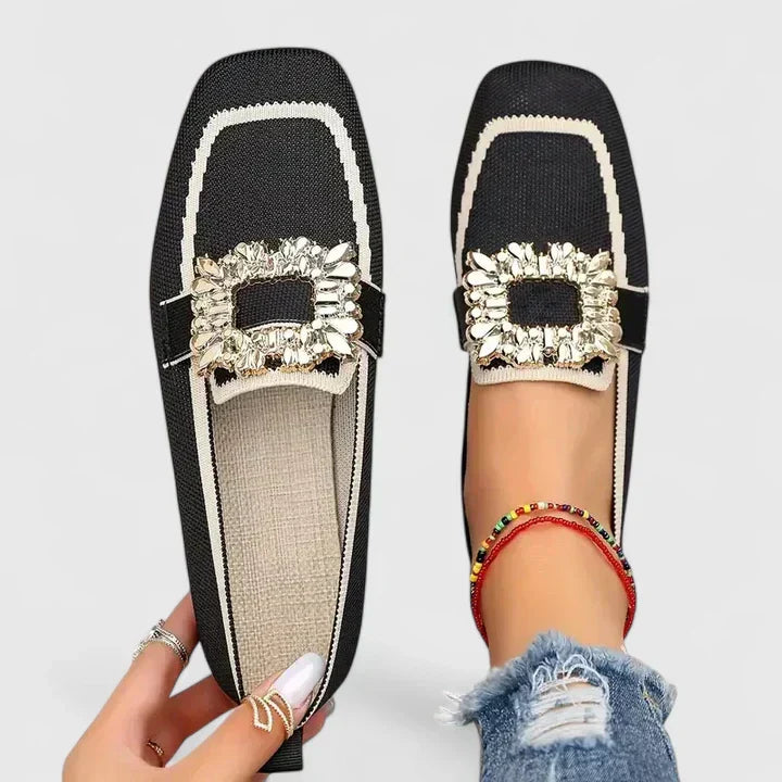 Female model showing classic slip-on loafers on a plain background.