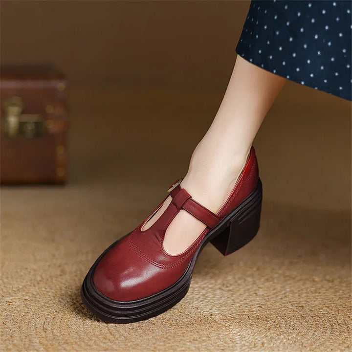 Woman standing in T-strap block heel shoes against a plain background.