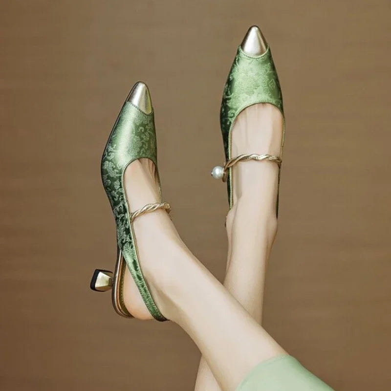 Elegant kitten heel shoe with metallic toe cap and twisted pearl ankle strap.
