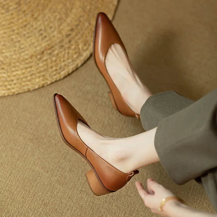 Female wearing elegant everyday pumps against a plain background.
