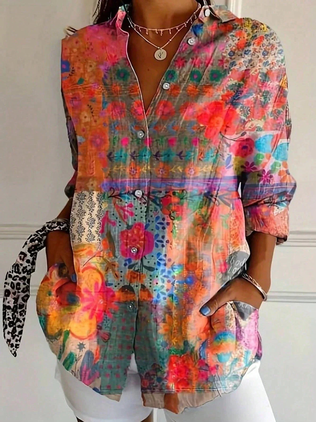  Woman showcasing a vibrant print blouse styled for everyday wear on a plain background.