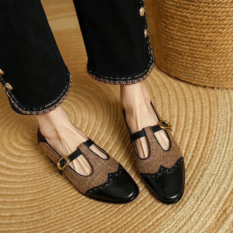 Female wearing two-tone T-strap Mary Jane shoes on a plain background.