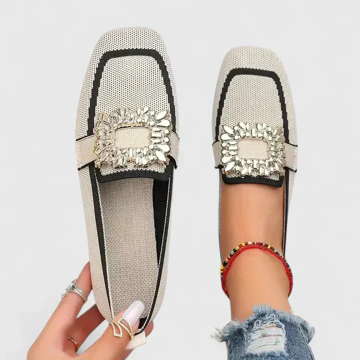 Woman standing in cushioned loafers against a plain background.