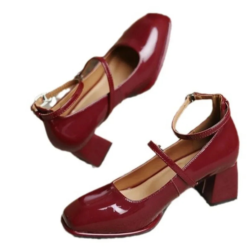 Glossy square toe dress shoes on a plain background.
