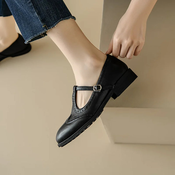 Model displaying vintage inspired T-strap shoes on a plain background.