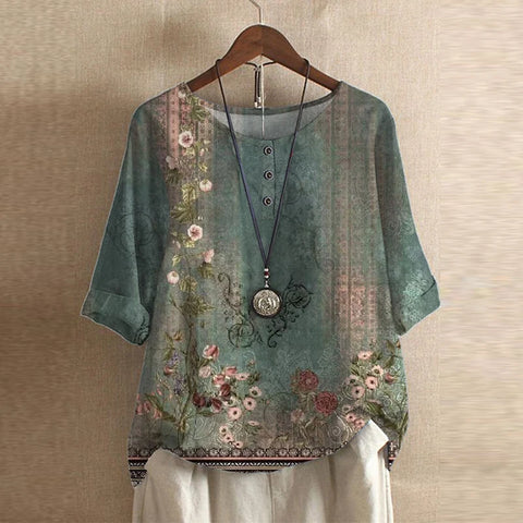 A vintage floral blouse with a relaxed fit against a plain background.ng.