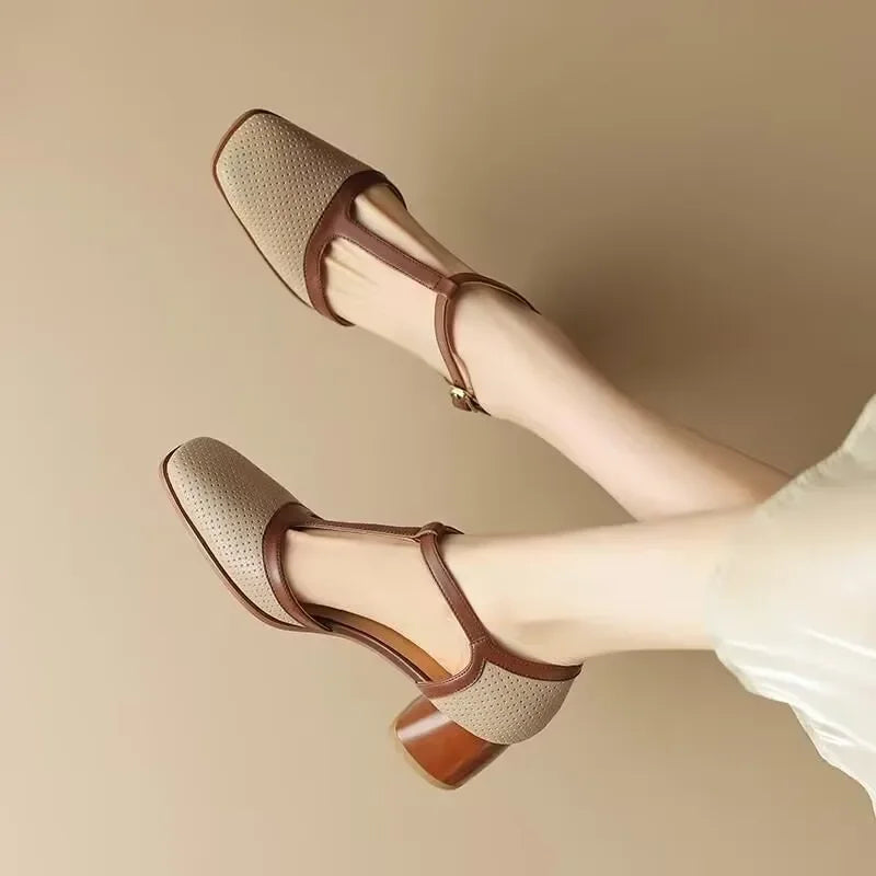 Female wearing two-tone T-strap dress shoes on a plain background.
