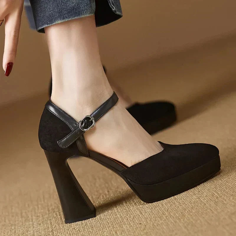 Woman standing in rounded toe platform pumps with block heels on a plain background.