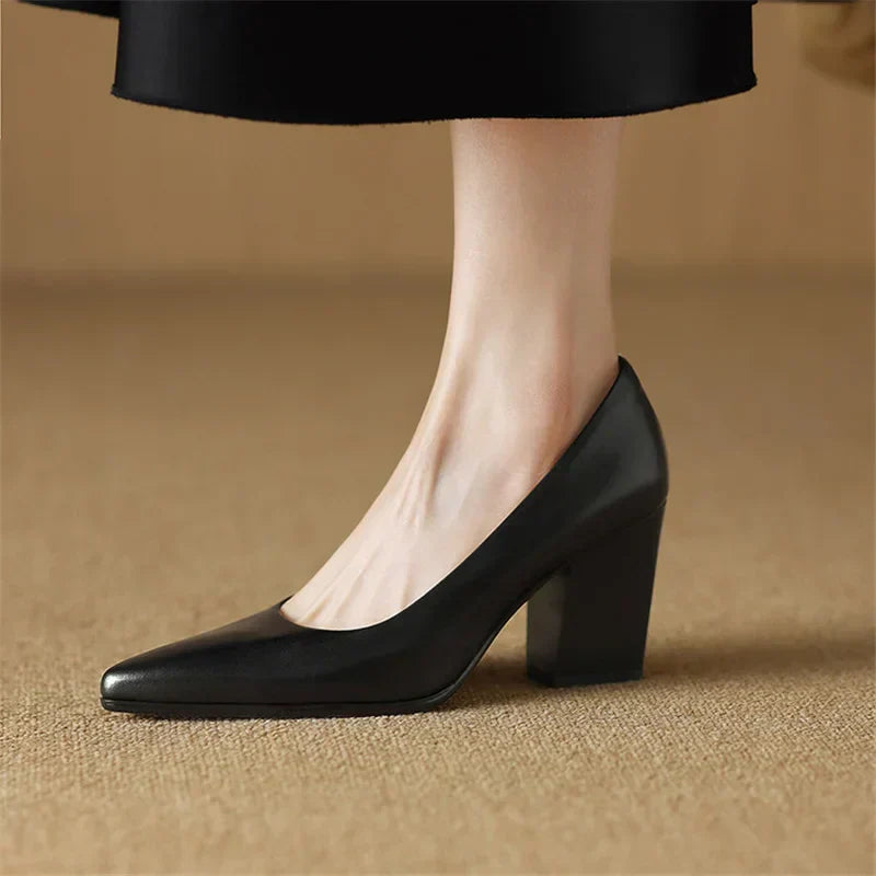 Female wearing slip-on tan pumps with a refined heel shape on a plain background.