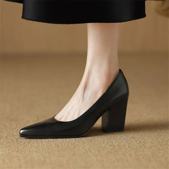 Female wearing slip-on tan pumps with a refined heel shape on a plain background.
