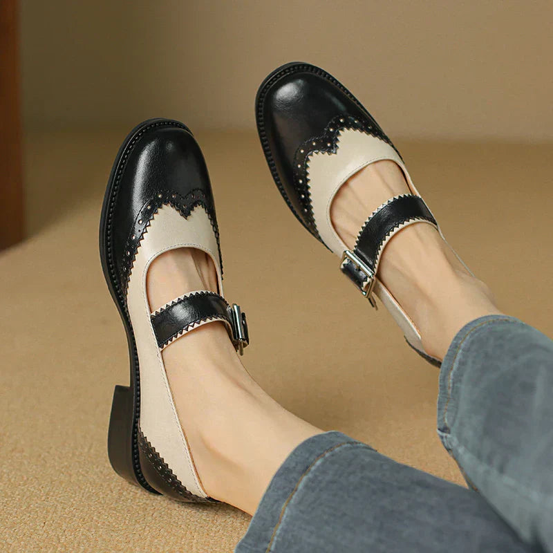 Woman wearing two-tone Mary Jane shoes on a plain background.