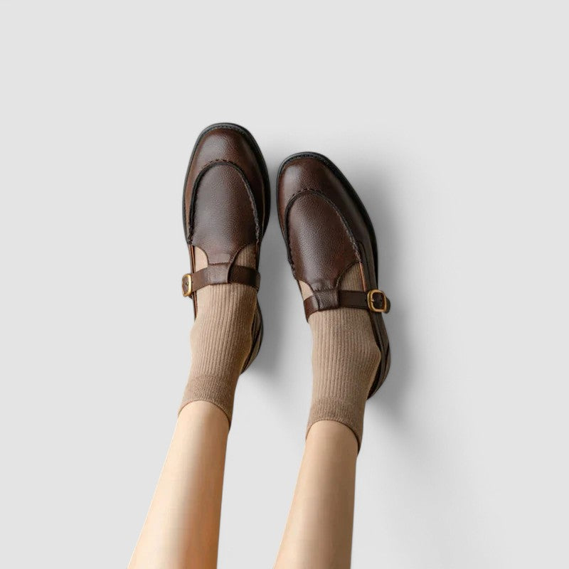 Female standing in strap Mary Jane shoes on a plain background.