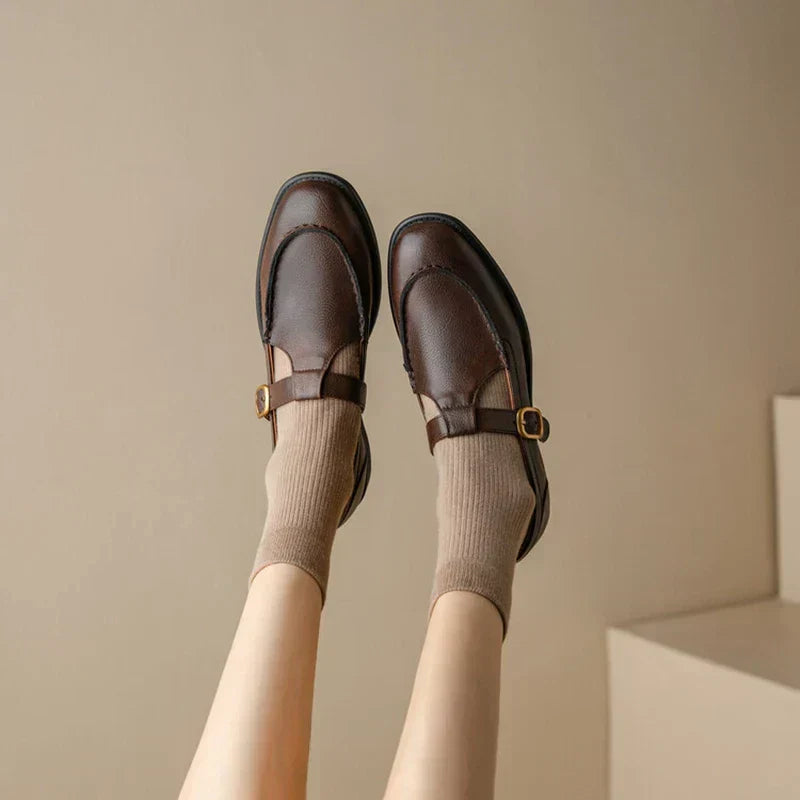 Female model wearing rounded toe Mary Jane shoes on a plain background.