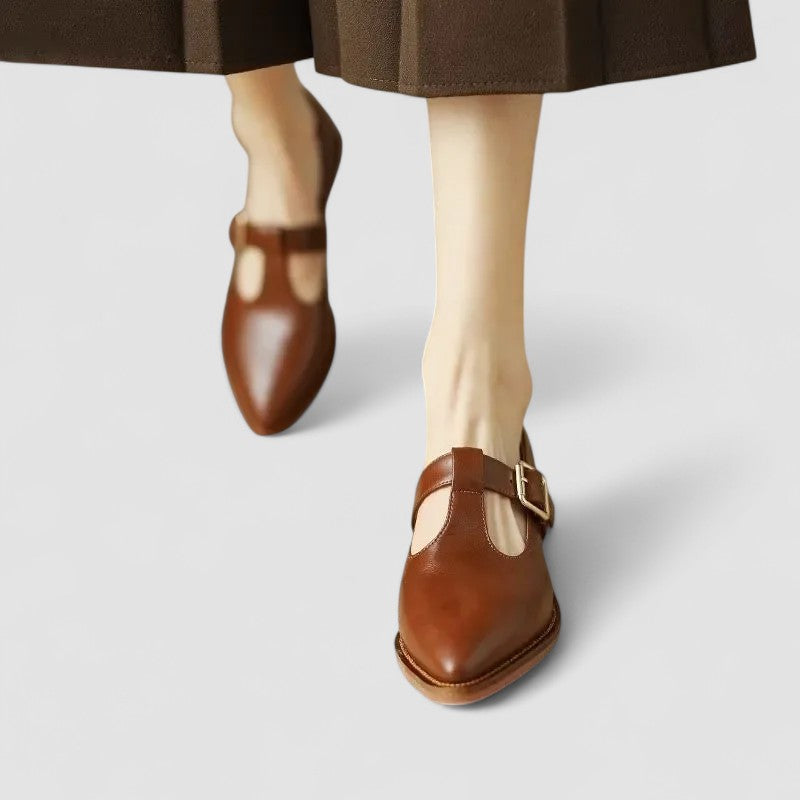 Female wearing classic slip-on shoes on a plain background.