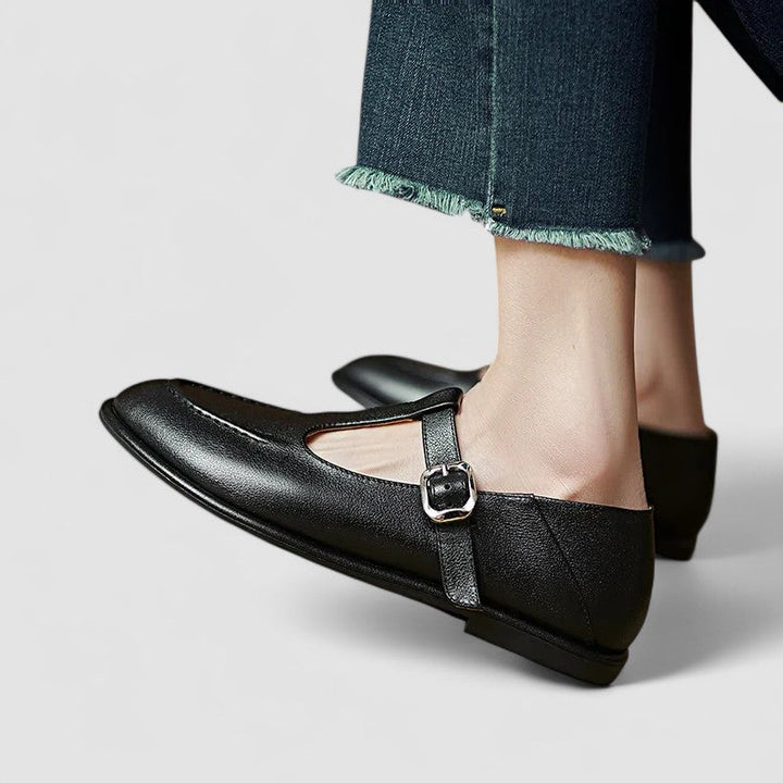 Female wearing smart low heel shoes on a plain background.