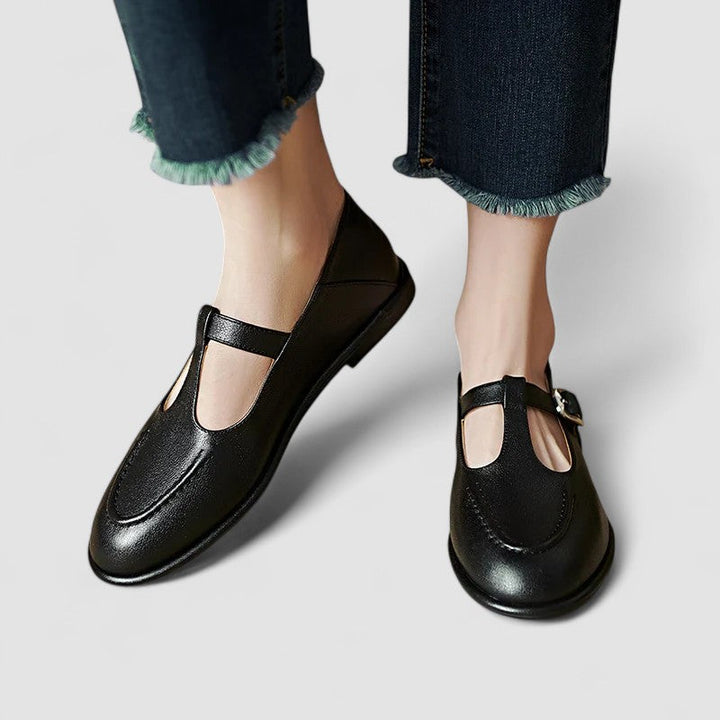 Woman wearing low heel shoes on a plain background.