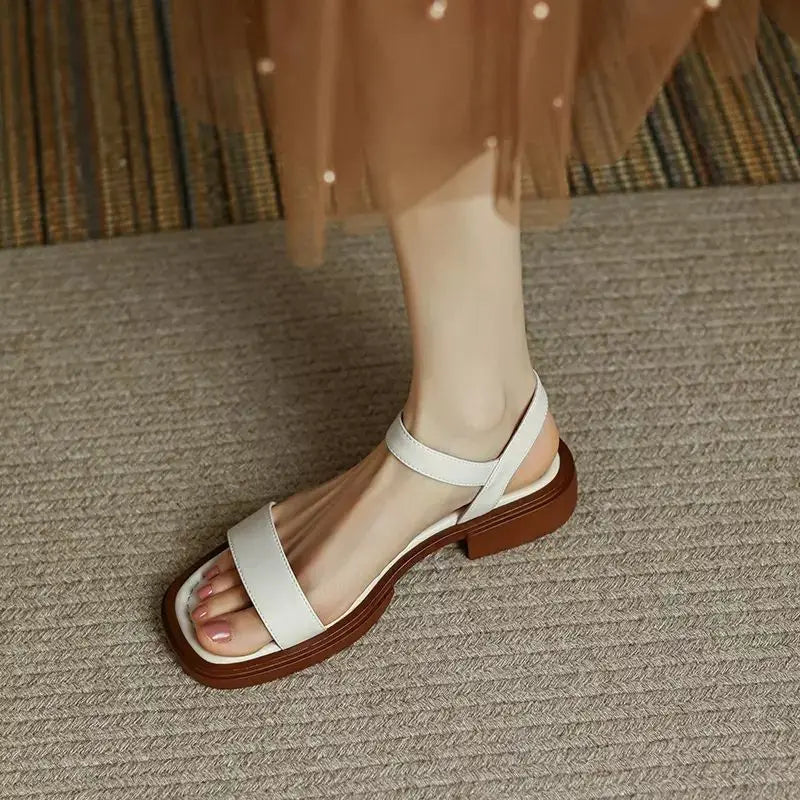 Female model posing in everyday sandals on a plain background