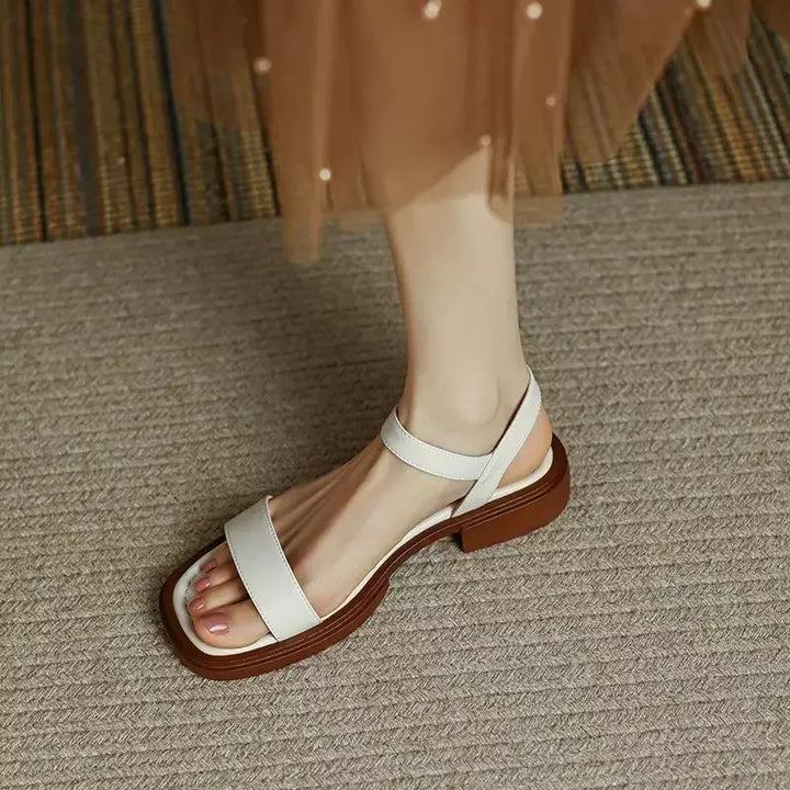 Female model posing in everyday sandals on a plain background