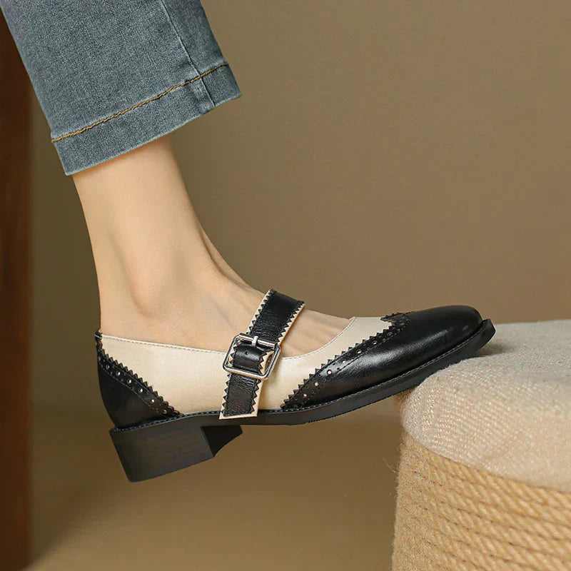 Female model wearing contrast Mary Jane flats with a T-strap on a plain background.