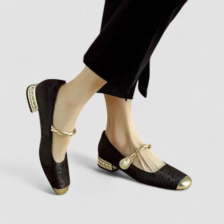 Female standing in classic strap shoes on a plain background.